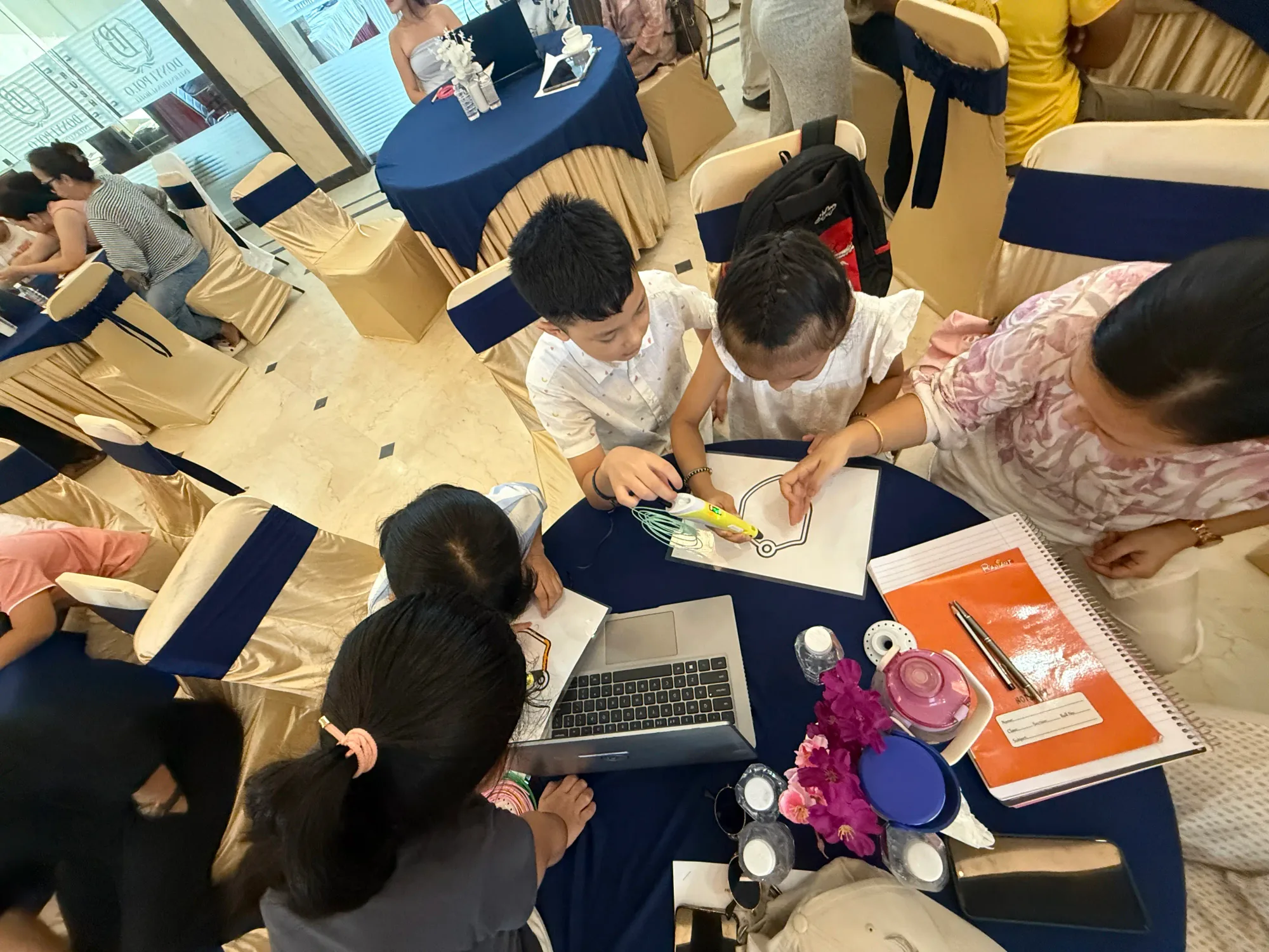 Students tracing a 3D pen design together at the NEbots workshop in Itanagar